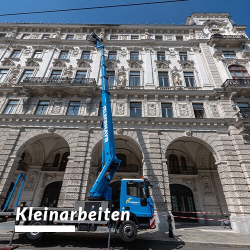 Foto einer Fassade in Wien. Davor ein Baukran bei der Arbeit.
